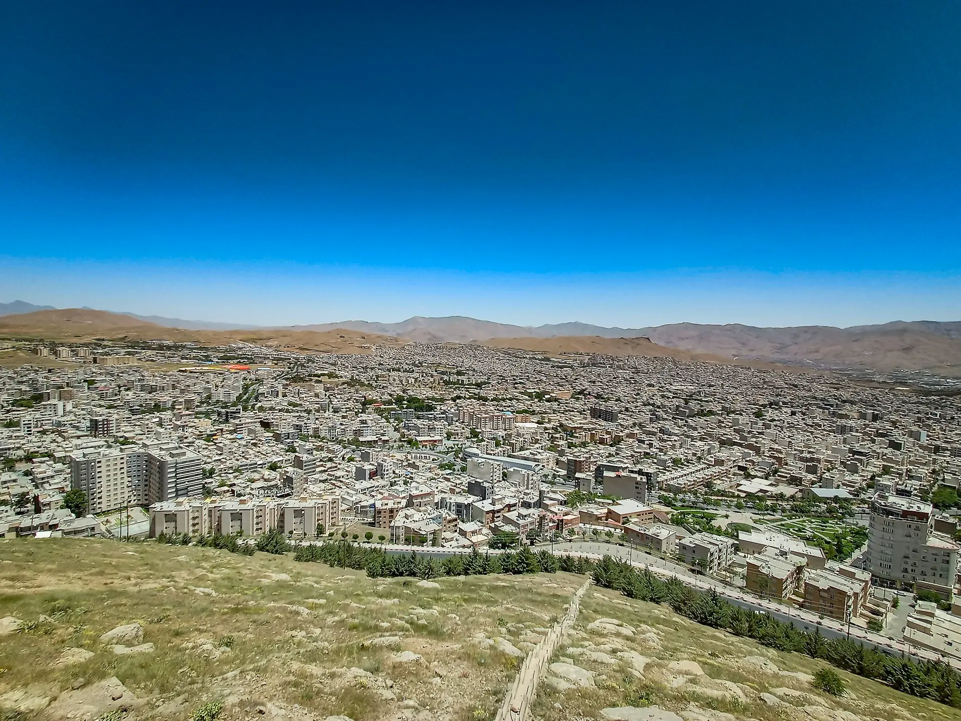 an aerial view of a city with mountains in the background