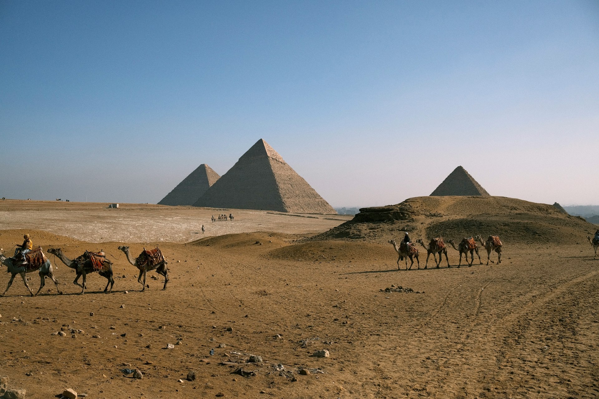 A group of people riding camels across a desert